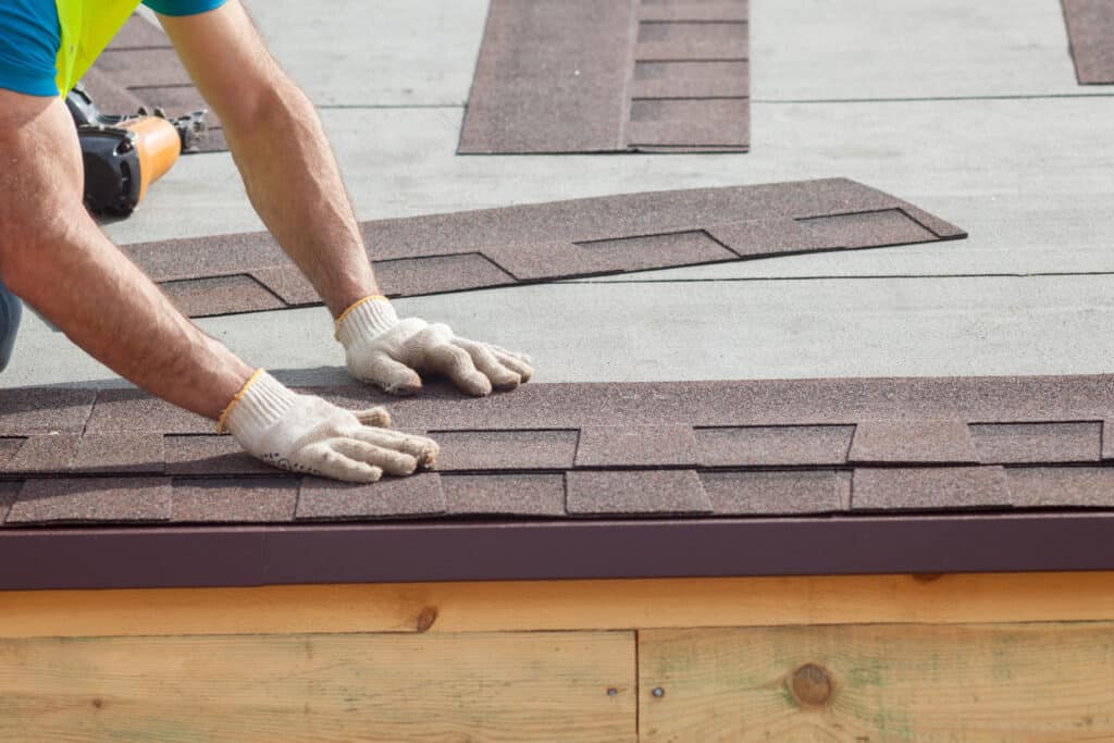 Roofer installing roof shingles on a home in Georgetown Township, MI.